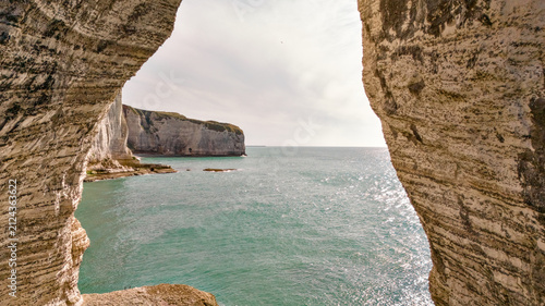 Foto Aerial view of a moody seascape and headland framed by a natural rock arch