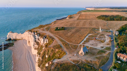 Fotografía Aerial view of dramatic white chalk cliffs meeting the ocean along a rugged coas