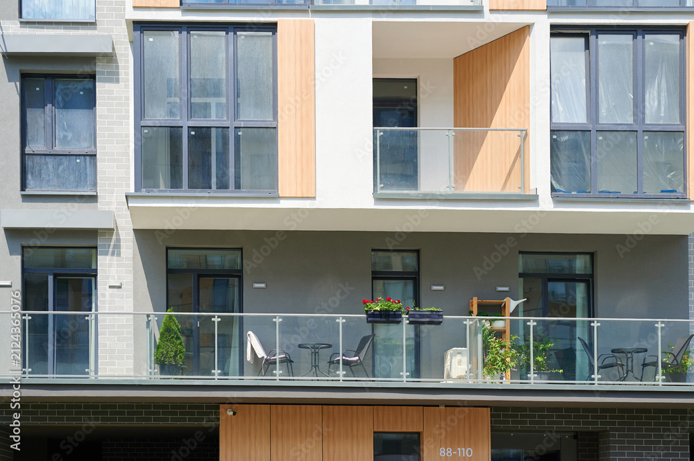 Fototapeta premium Modern residential building facade with glass balconies and contemporary design