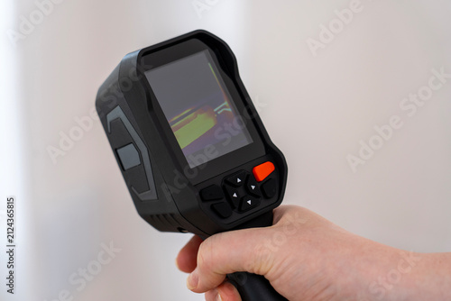 Foto Black handheld thermal camera features a color screen showing heat patterns