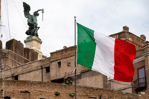 Fotografie Italian tricolour flag green white red windblown on flagstaff in Rome and cloudy