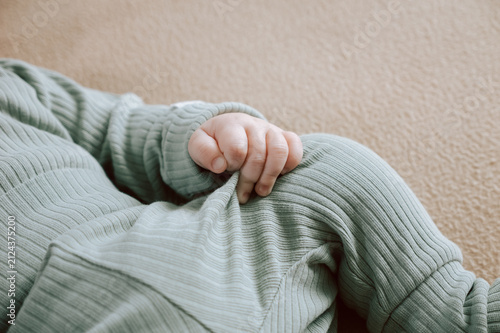 Little hand of a cute baby with selective focus. Adorable newborn boy fingers close up