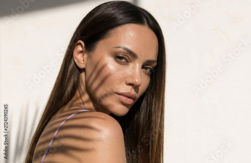 Картината върху платно Dramatic natural lighting creates striking shadow stripes across a woman's face