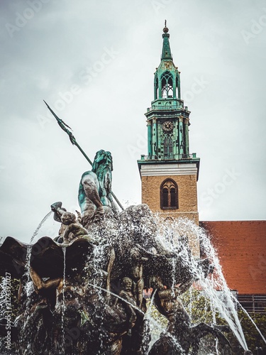 Bild auf Leinwand Neptunbrunnen in Berlin mit Neptun Skulptur und Turm der Marienkirche
