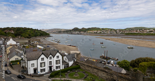 Conwy Wales, uk, April 20th 2025 Coastal Town Harbor with Boats and Historic Castle Walls Overlooking a Wide Estuary