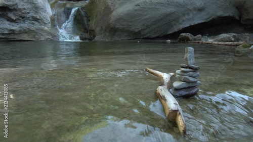 Zen Steine Stapel im fliessend Gewässer mit Wasserfall im Hintergrund - Natur und Entspannung