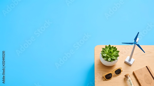 a desk with a plant, glasses and a phone on it
