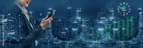 Obraz na plátne A business professional engages with a smartphone surrounded by digital graphs and a city skyline, symbolizing future growth in market trends and financial success