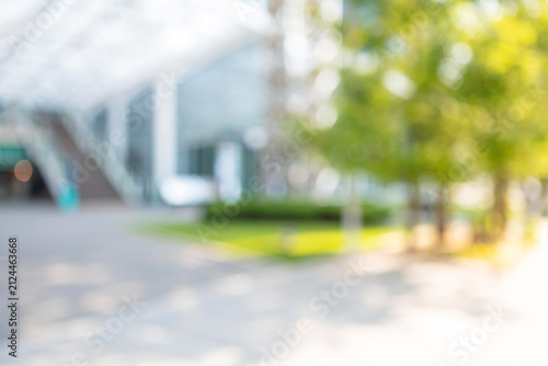 Abstract blurred modern shopping mall plaza background with green garden