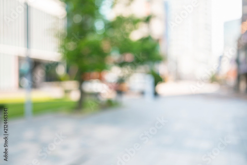 Abstract blurred modern urban pedestrian plaza background with green trees