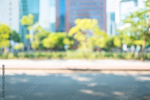 Obraz na płótnie Abstract blurred modern city avenue background with green trees and skyscrapers