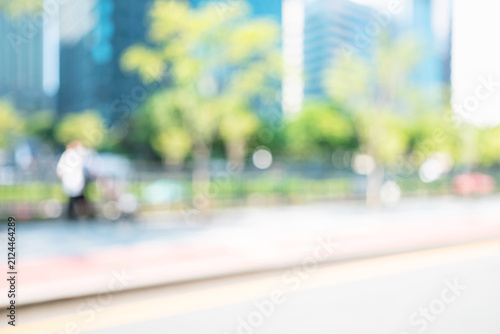 Bild auf Leinwand Abstract blurred modern city avenue background with green trees and moving pedes