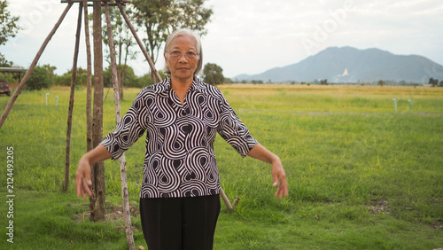 Asian senior woman stretching arms outdoor and washing hands at sink. Active aging lifestyle and hygiene healthcare concept for elderly.