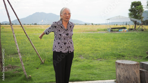 Asian senior woman stretching arms outdoor and washing hands at sink. Active aging lifestyle and hygiene healthcare concept for elderly.