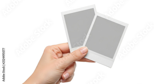 Hand holding two blank vintage style polaroid photo frames isolated on transparent background