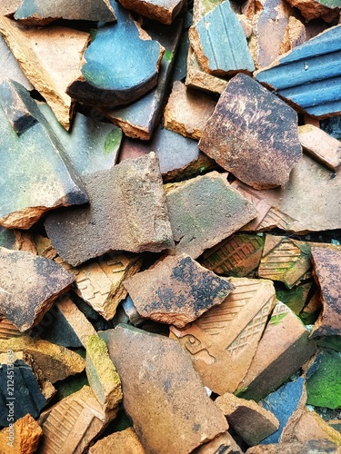 Pile of Weathered Terracotta and Blue Tile Shards, Top-Down View. 