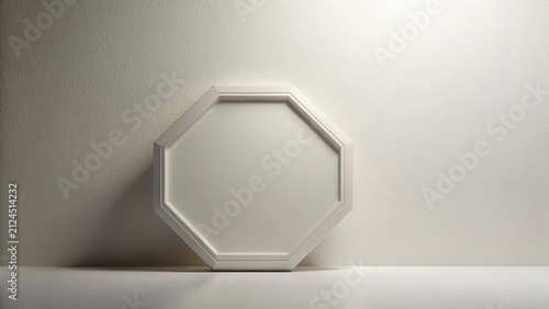 A simple white octagonal frame rests on a surface against a textured wall background, providing a clean and minimalist aesthetic for various design applications.
