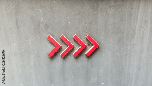 Red arrow shapes, red arrows arranged side-by-side, gray concrete, concrete wall, gray, background, texture