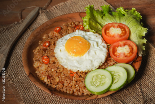 Canvas Print Fried rice with fried egg on top and vegetable as a garnish