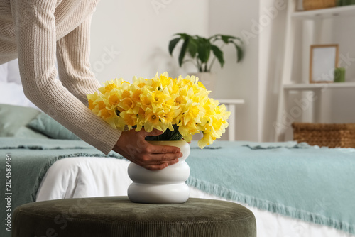 Woman with daffodils in bed...