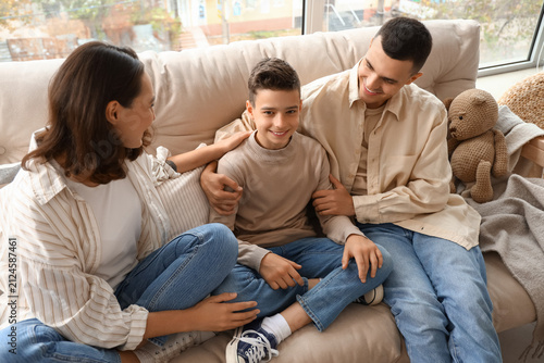 Little boy with his parents sitting on couch at home