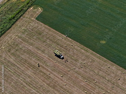 Collecting hay and grass in a large field. The view from the drone.