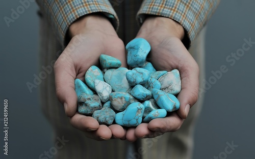 Hands holding turquoise stones symbolizing natural beauty, minerals, and geological aesthetic appeal