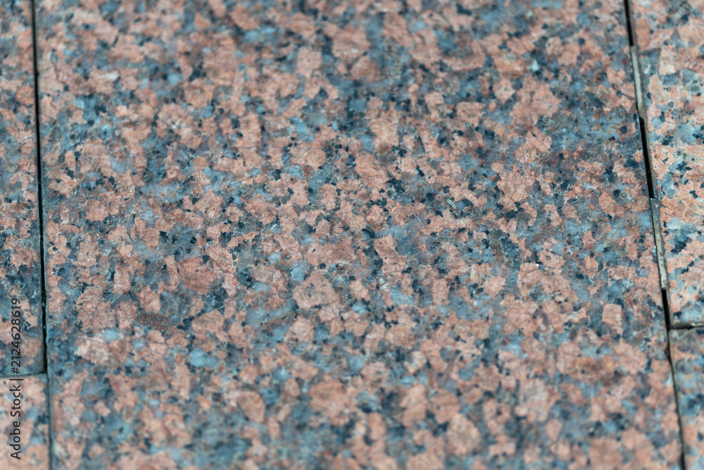 Fototapeta premium Granite tiles with a blend of colors create a mesmerizing texture for outdoor spaces in a sunny afternoon setting