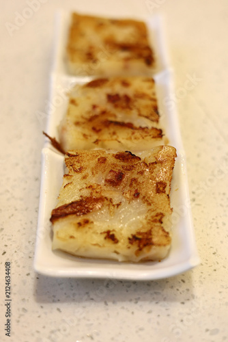Wall Mural Pan-fried radish cakes served neatly on a white ceramic plate.