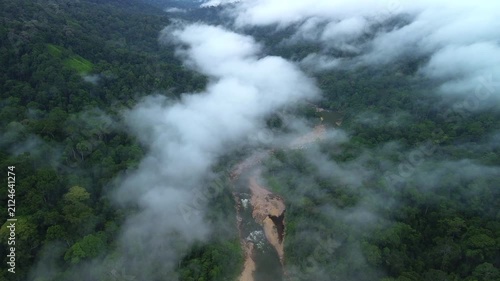 Drone flyover descending toward Sungai Tembeling winding through misty primary tropical rainforest, Al-Sultan Abdullah Royal Tiger Reserve, Pahang, Malaysia