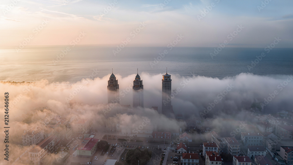 Fototapeta premium Misty Sunrise Over Coastal Buildings