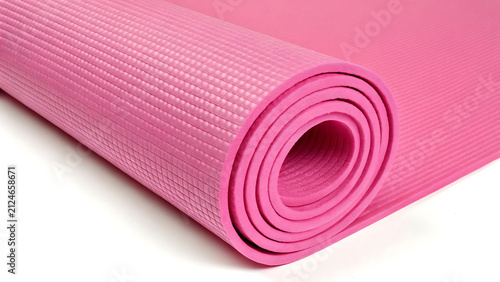 Rolled pink yoga mat ready for fitness practice. Vibrant exercise mat in soft texture for home workouts and studios.