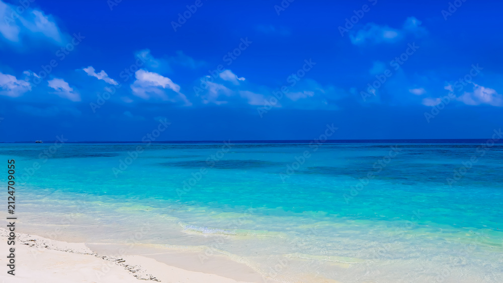 Fototapeta premium The background for summer vacation concept with the nature of clear water sea beach and summer with sunlight, sandy beach as The sparkling sea water contrasts with the blue sky