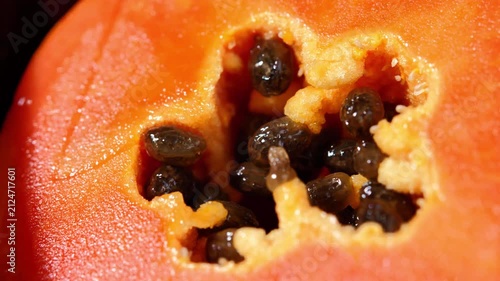 Close-up of ripe papaya flesh and glossy black seeds, showcasing the vibrant orange color and natural texture of this tropical fruit. Rich in vitamins, antioxidants, and dietary fiber, the image is id