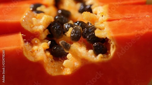 Close-up of ripe papaya flesh and glossy black seeds, showcasing the vibrant orange color and natural texture of this tropical fruit. Rich in vitamins, antioxidants, and dietary fiber, the image is id