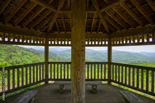 Fotografía Scenic landscape view of layered green mountains framed by a wooden gazebo pavil