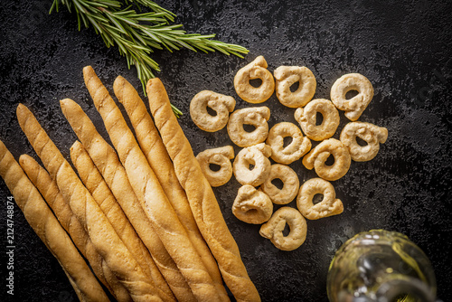 Foto Rustic Italian Breadsticks and Taralli With Rosemary and Olive Oil on Dark Slate