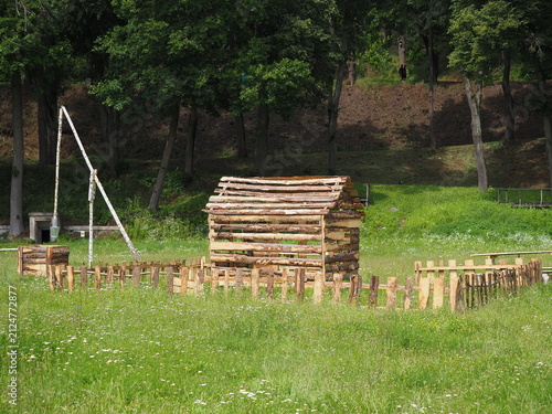 A house, a fence and a well made of planks