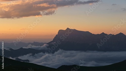 Mountain timelapse landscape at sunset with clouds rolling over the valley below
