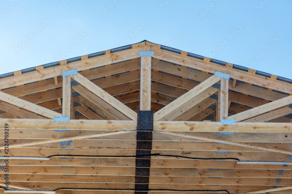 Obraz premium Under construction: A rustic wooden roof frame stands bold against a vibrant