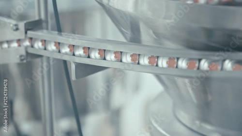 Protective caps for medical bottles at production line. Production equipment at medical industry. Close-up in 4K, UHD