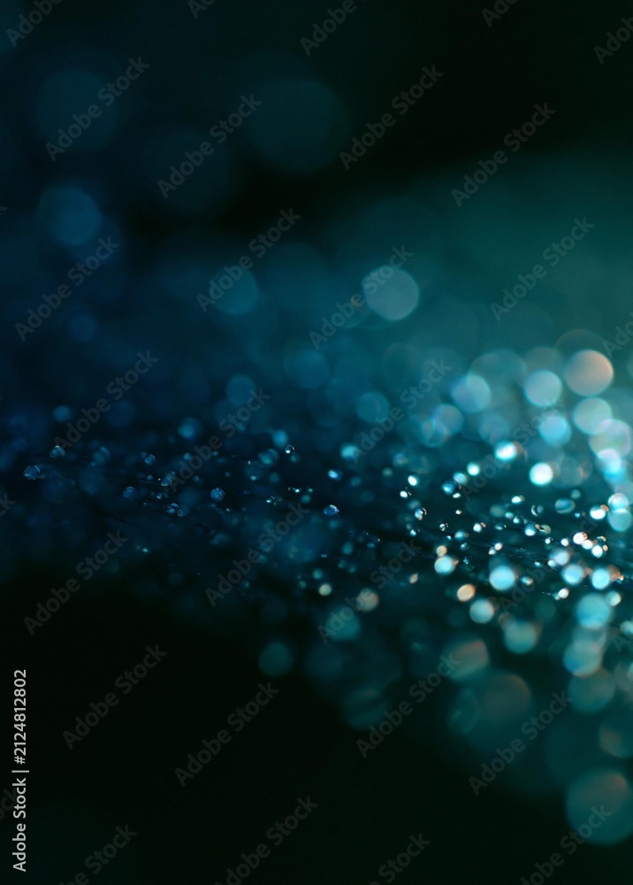 Fototapeta premium Close-up of a dark blue background with small white dots scattered across it. the dots are of different sizes and shapes, creating a bokeh effect.