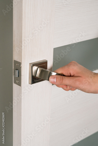 Foto Hand opening modern door handle with light wood finish