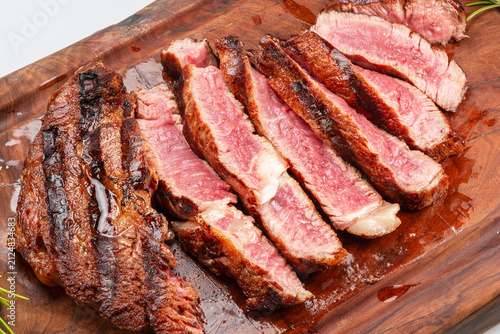 Bild auf Leinwand Sliced grilled beef ribeye steak medium rare on wooden cutting board