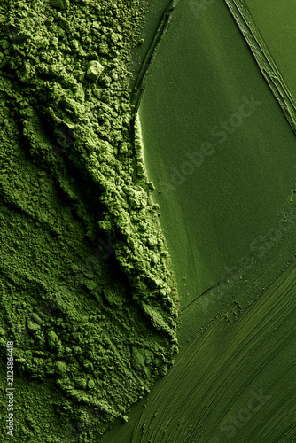 Matcha powder brushed on a green background. Ideal for backgrounds and advertising.