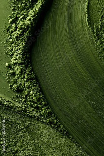 Matcha powder brushed on a green background. Ideal for backgrounds and advertising.