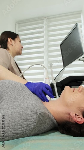 Doctor uses probe to examine patient neck by ultrasound scanning in clinic. Woman expresses trust to expert at procedure in hospital