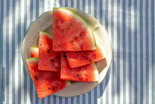 Top View of Sliced Juicy Watermelon on Plate with Blue and White Striped Tablecloth