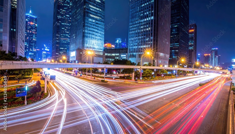 Naklejka premium Urban nightscape with blurred light trails across a wide avenue, buildings towering in the background