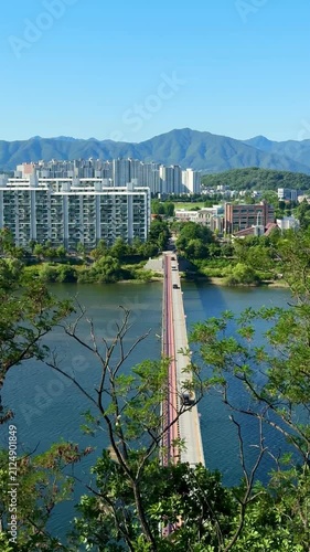 Beautiful aerial view capturing the cityscape of of Chuncheon with Soyanggang river view and the bridge. Mountains, big road and residential apartments buildings and beautiful green hills from afar